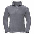 The Russell 8740M gray fleece quarter-zip jacket is showcased on a plain background. This jacket boasts long sleeves and a relaxed fit, complete with a zipper extending from the chest to the collar and side pockets equipped with zippers.