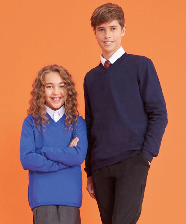 Two children, a girl and a boy, stand against an orange background. Both are wearing AC003 by AWDis Academy, with white shirts underneath. The girl has curly hair and the boy has short hair; both are smiling.