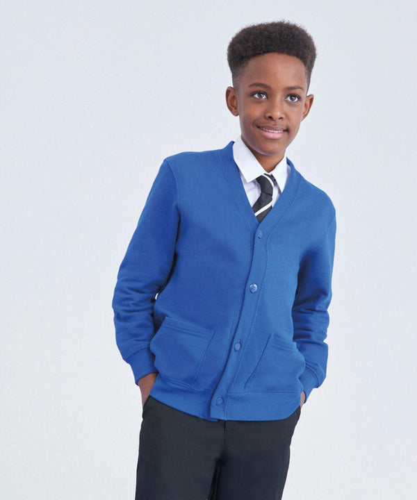 A young boy stands confidently with his hands in his pockets. He is wearing a blue AC02J cardigan from AWDis Academy over a white shirt and a black and white striped tie. The boy has short hair and is smiling slightly, posing against a plain white background.