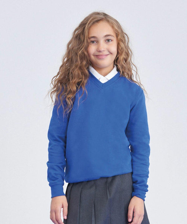 A young girl with long, wavy hair is smiling at the camera. She is wearing an AWDis Academy AC03J blue sweater over a white collared shirt and a gray skirt. The background is plain and light-colored.