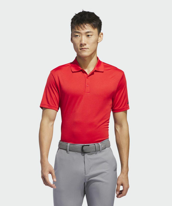 A person wearing a red AD002 by adidas and gray pants, with a gray belt, stands against a plain white background.