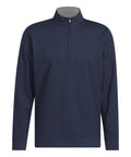The Sports Overtops is a navy blue long-sleeve pullover featuring a quarter-zip fastening, stand-up collar with light grey inner lining, and smooth material. Its design is simple and unadorned.