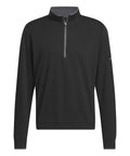 The Sports Over-top is a black long-sleeve quarter-zip pullover featuring a stand-up collar, grey zip, and a subtle logo on the left sleeve, shown against a plain white background.