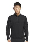 A man with short hair and a neutral expression wears the adidas UPF lightweight quarter-zip pullover in black, featuring a small sleeve logo, whilst standing against a plain white background.