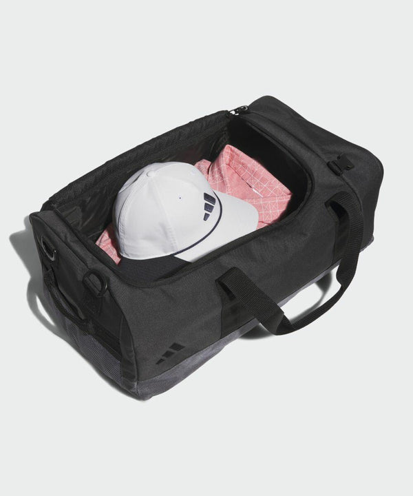 Open black duffel bag containing a white cap and pink garment, positioned on a white background by adidas AD195.
