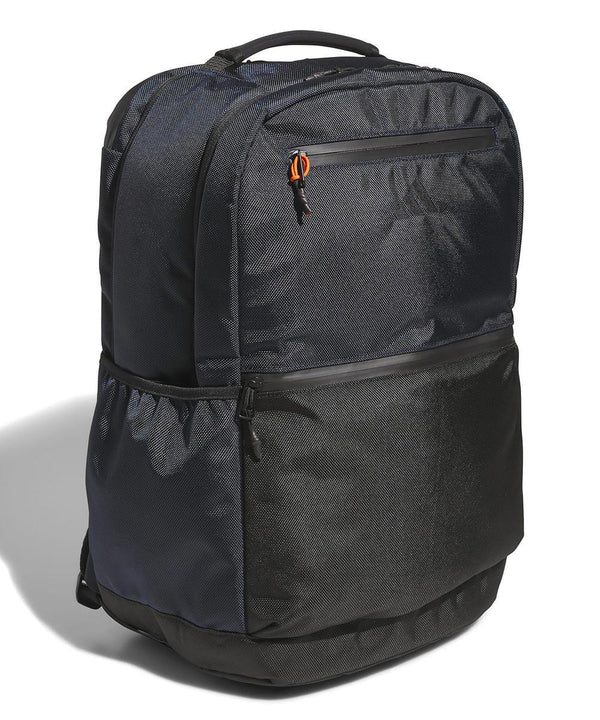 The adidas Rucksack is black and dark grey with a top handle, front and side zippered pockets, and a mesh side pocket, displayed against a white background.
