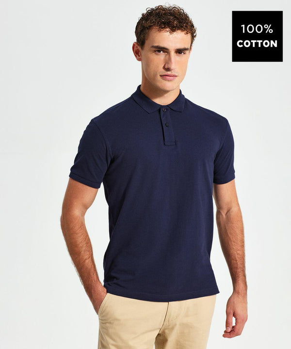 A man wearing a navy blue polo shirt and beige pants stands against a plain background. A label on the right side of the image says "100% Cotton AQ010 by Asquith & Fox.