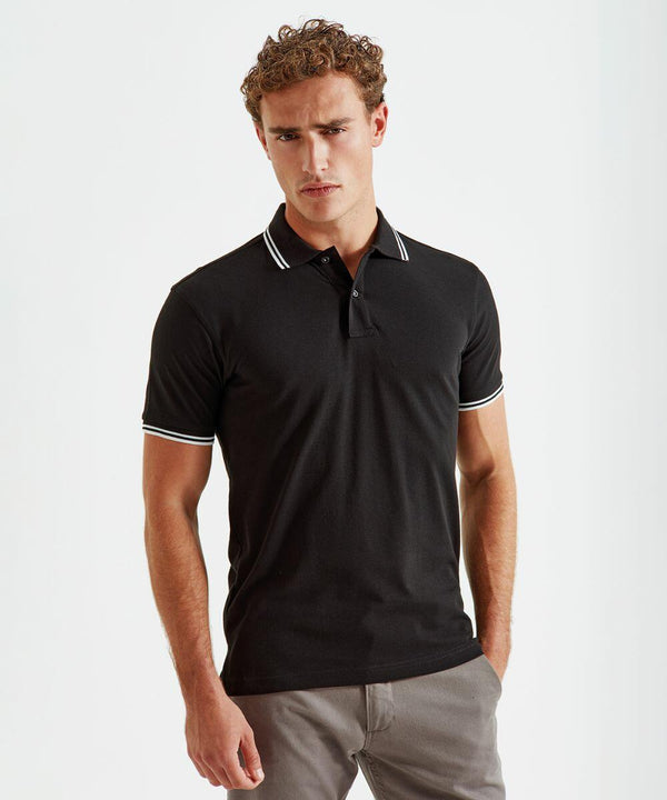 A person wearing an Asquith & Fox AQ011 black collared shirt with white trim on the collar and sleeves, paired with gray pants, stands against a plain background.