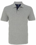 The Asquith & Fox AQ012 is a light gray polo shirt with short sleeves and a collar. It includes a buttoned placket and an elegantly contrasting inner lining at the neckline, made from soft and comfortable fabric ideal for casual or semi-formal occasions.