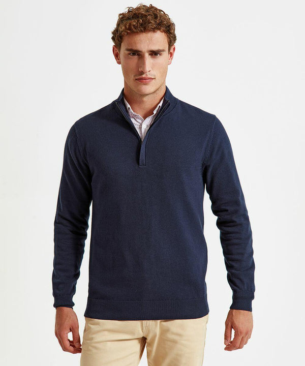 A man with curly hair is wearing an Asquith & Fox AQ048 quarter-zip sweater over a collared shirt. He is also wearing light beige pants. He stands against a plain white background, looking straight at the camera with a neutral expression.