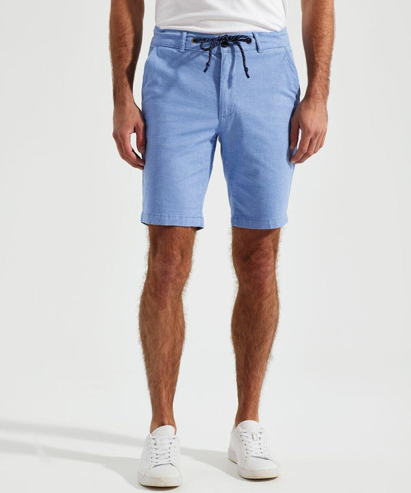 A person wearing light blue drawstring AQ057 shorts by Asquith & Fox, a white shirt, and white sneakers is standing against a plain white background.