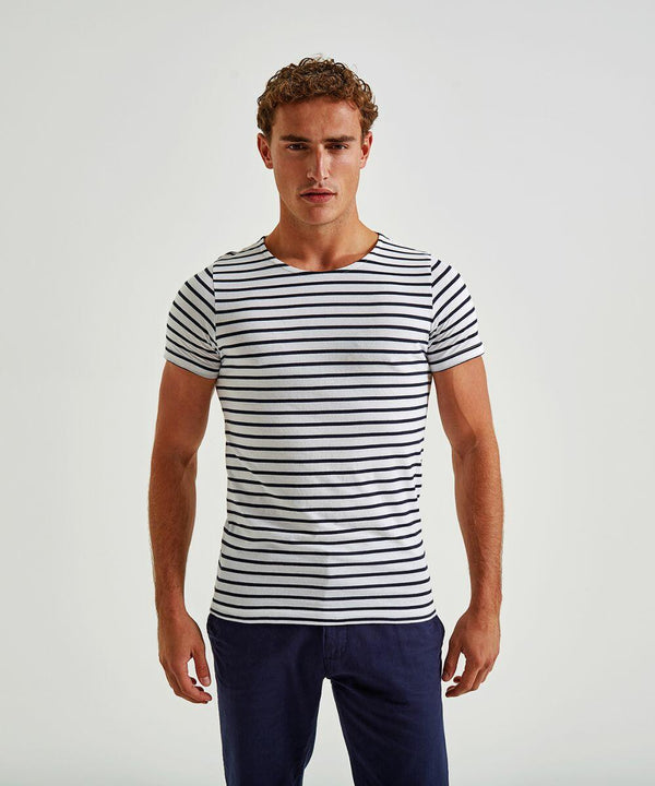 A man standing against a plain background, wearing an Asquith & Fox AQ072 fitted, short-sleeved, white t-shirt with black horizontal stripes, and dark blue pants. He has short, curly hair and is facing the camera with a neutral expression.