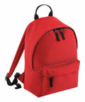 A vibrant red Bagbase B125S with a black handle and adjustable shoulder straps. It features a large main compartment with two black zippers and a smaller front pocket, also with a black zipper. The design is simple and functional.