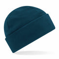 A Beechfield B243R beanie with a folded brim is showcased against a white background. The fabric looks soft and warm, indicating its suitability for cold weather. Its simple design emphasizes the solid color and cozy texture.