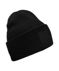 The Beanies is a black knitted beanie featuring a turned-up brim and a rectangular blank patch on the front, shown against a white background.