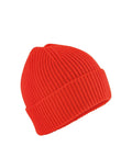 A vibrant red beanie knitted hat with a folded cuff is shown against a plain white background.