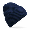 The Beechfield B384R, a navy blue ribbed knit beanie featuring a folded cuff, is showcased against a white backdrop, creating a subtle shadow underneath.
