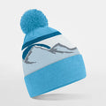 Beechfield's B395R beanie in light blue features a pom-pom, a mountain design, and dark blue stripes on a white background.