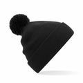 Product B426B by Beechfield, a black knit beanie featuring a pom-pom on top, is displayed against a white background.