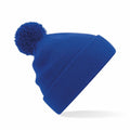 A Beechfield B426B blue knit beanie adorned with a pom-pom, set against a white background.