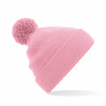 The Beechfield B426B is a pink knit beanie featuring a large pom-pom on top, complemented by a thick folded cuff and presented against a plain white background.