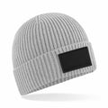 A gray ribbed knit beanie from Beechfield, model B442R, featuring a black rectangular patch on the front. The beanie is showcased on a white background, slightly angled with shadows beneath it.