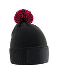 The Beanies is a black knitted beanie with a rectangular front patch and a pom-pom in black and bright pink accents.