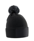 The Beanies is a black knitted hat with a bobble and a blank rectangular patch on the front, displayed on a white background.