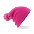 A Beechfield B450B, a knit beanie in pink featuring a pom-pom on top, displayed against a white background.