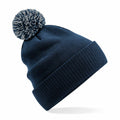 The Beechfield B450R, a navy blue winter beanie featuring a pom-pom on top, is displayed against a plain background.