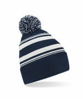 A knitted blue and white striped beanie featuring a pom-pom on top, known as the Beechfield B473R.