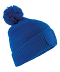 Beanies: Blue knitted hat with ribbed texture, large bobble on top, and circular patch on the turned-up brim.