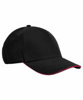 A black Beechfield B825C baseball cap with a plain design. The cap features a curved bill with a thin red line along the edge, adding a subtle accent to its overall look. The crown is structured and fitted with a top button.