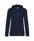 A BA02F black zip-up hoodie from B&C Collection, featuring a front zipper, two pockets, and an adjustable drawstring hood, is displayed on a plain white background.