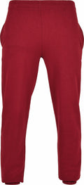 BB002 by Build Your Brand Basic are red sweatpants featuring an elastic waistband and cuffs, displayed from the front.