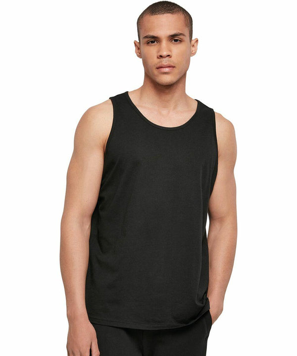 A person with short hair is wearing a black sleeveless BB011 by Build Your Brand Basic and black pants. They are standing against a plain white background, looking directly at the camera with a neutral expression.