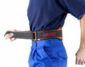 A person wearing blue pants and a navy blue shirt fastens a black lumbar support belt around their waist. The belt has a red logo that says "Beeswift Atlas." The person is shown from the waist down, and the background is plain white.