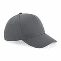 The Beechfield BC018 is a grey baseball cap designed with a curved brim and six panels, highlighted by stitched seams and an adjustable strap at the back. It is displayed against a plain white background.