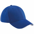 A Beechfield BC020 baseball cap in blue, featuring a curved brim with white lining along the edge, visible stitching, and a button on top.
