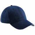 A plain navy blue Beechfield BC020 baseball cap features a curved brim with white trim along the edge, set against a white background.