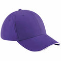 The BC020 by Beechfield is a purple baseball cap featuring a curved brim and reinforced stitching on the panels and brim, set against a white background.