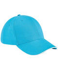 Introducing the Beechfield BC020, a vibrant blue baseball cap that boasts a six-panel design with a curved brim. This stylish cap includes stitched eyelets for ventilation and a small button on top, complemented by a white accent line along the edge of the brim.