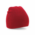 The Beechfield BC044 beanie, in a vibrant red with a smooth ribbed texture, is displayed against a plain white background. The beanie is slightly angled to highlight its simple, casual style.