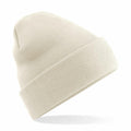 A Beechfield BC045 beige knitted beanie featuring a folded brim, isolated on a white background.