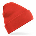 The BC045 by Beechfield is a vividly red knit beanie featuring a folded cuff, set against a plain white backdrop. Positioned at a slight angle, it highlights its rich texture and lively color.