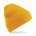 A vibrant yellow knit beanie from Beechfield, model BC045, is positioned on a plain white backdrop. It features a folded brim and is slightly tilted to the side, casting a gentle shadow beneath it.