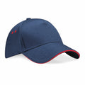 The BC15C by Beechfield is a blue baseball cap featuring a curved brim with red accents along the edge and ventilation holes.