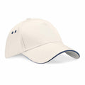 A Beechfield BC15C baseball cap in plain beige features a curved brim and two small ventilation holes on the side, highlighted with a subtle blue lining along the edge. The cap is showcased against a white background.