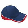 The Beechfield BC171 is a blue baseball cap with a red brim and sides, accented by white piping along the edges. It includes ventilation holes on the side for added comfort.