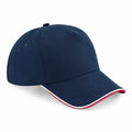 A navy blue Beechfield BC25C baseball cap featuring a curved brim with red and white accents along the edge. It has a round top with a small button at the center.